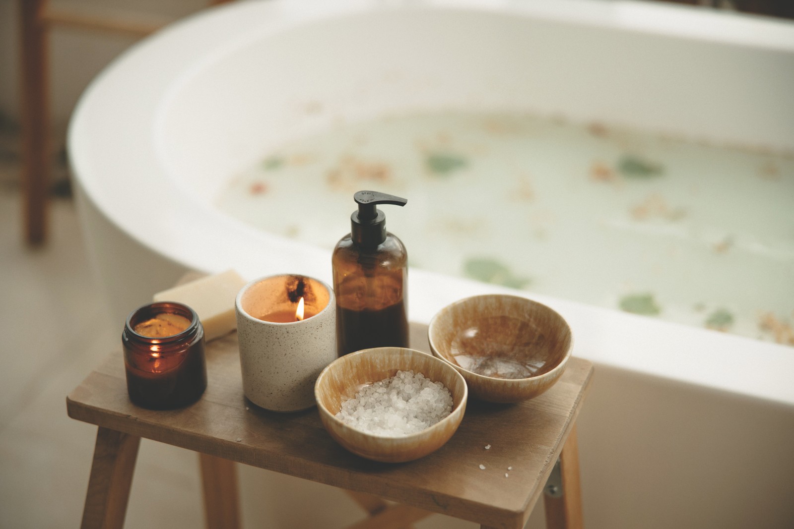 A New Year’s Gentle Reset – Bath Ritual Candlelit bath with bath salts and oils on a wooden stool