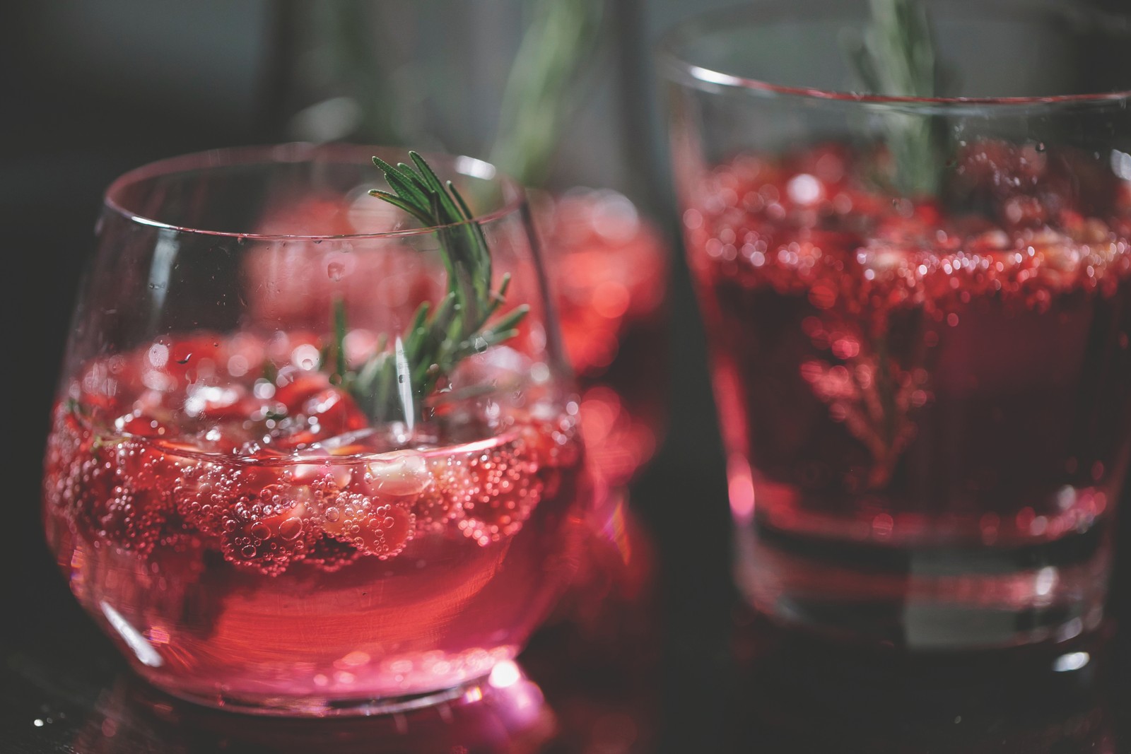 Merry Hour – Cranberry Rosemary Holiday Cocktails Cranberry holiday cocktails garnished with rosemary sprigs