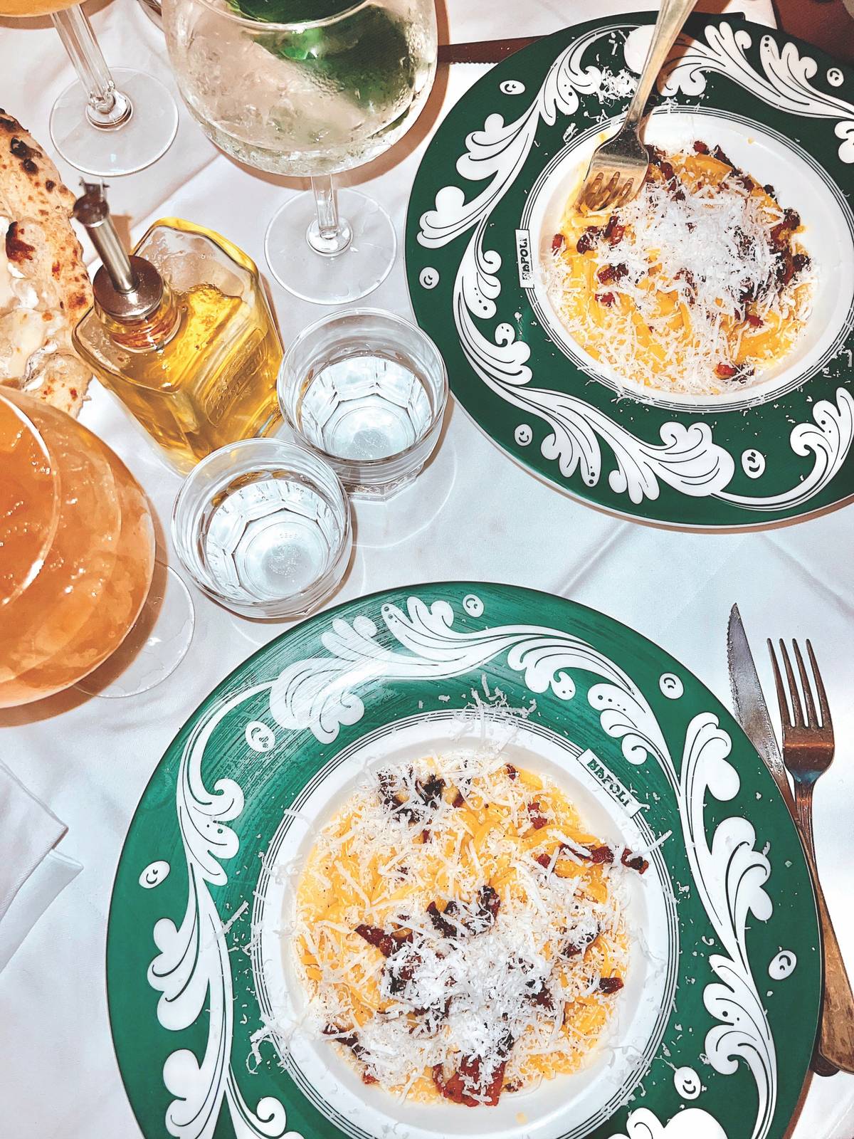 Starry Nights – Dining Table Overhead view of a dinner table set with pasta on green-and-white plates and wine glasses