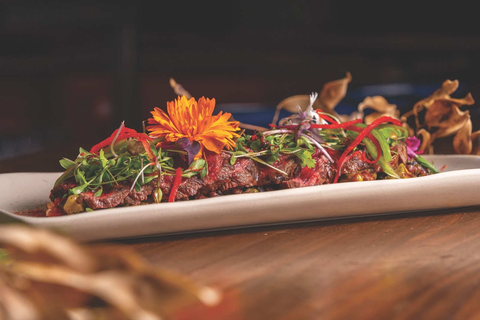 Starry Nights – Garnished Platter Grilled dish garnished with herbs and edible flowers on a long platter